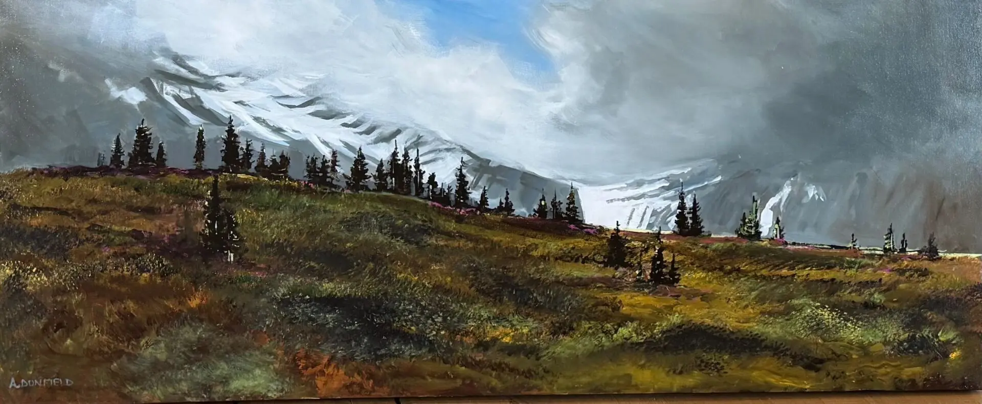 Mountain landscape with trees and cloudy sky.