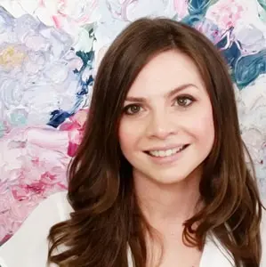 A woman with long brown hair smiling for the camera.