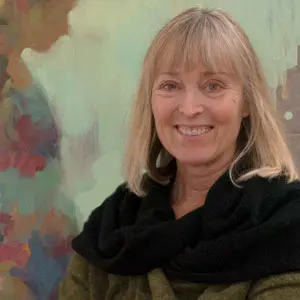 A woman standing in front of a painting.